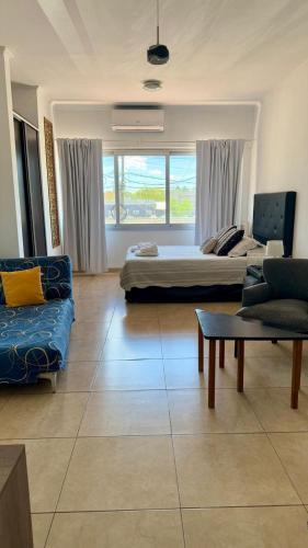 a living room with a bed and a couch at Punto Maschwitz Alquileres - Monoambiente in Ingeniero Maschwitz