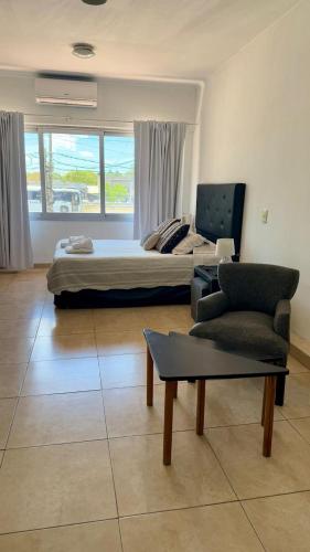 a bedroom with a bed and a couch and a chair at Punto Maschwitz Alquileres - Monoambiente in Ingeniero Maschwitz