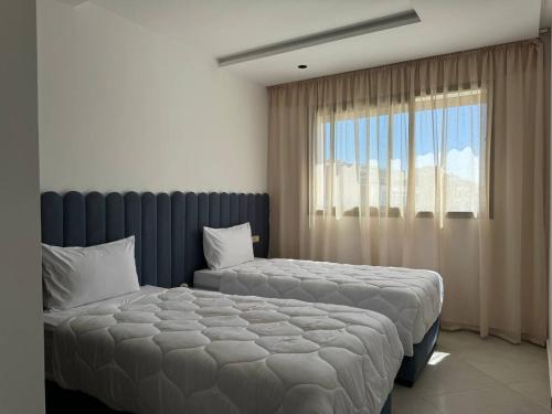 盖尼特拉Nouvel Appartement Confortable Avec Netflix & IPTV的有两张床和一扇窗户的卧室