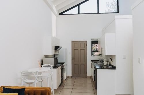 a kitchen with white cabinets and a brown door at Ihita unit 11 in Sandton