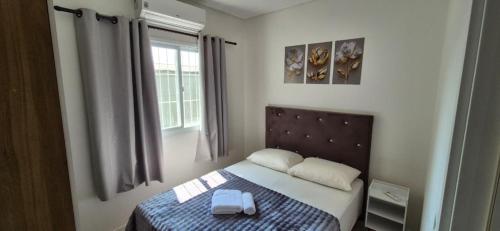 a small bedroom with a bed and a window at MM Apart Premium Joinville in Joinville