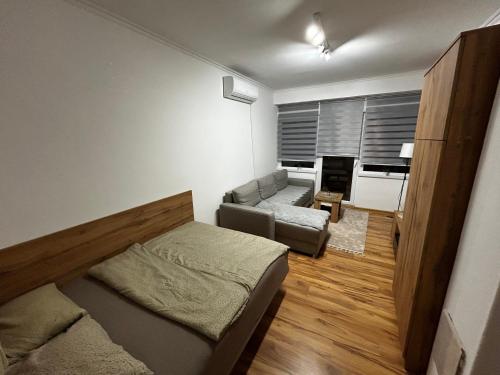a small room with a bed and a couch at Mance apartments 2 in Paraćin