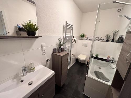 a bathroom with a sink and a tub and a toilet at Apartment-Topnik Datteln in Datteln