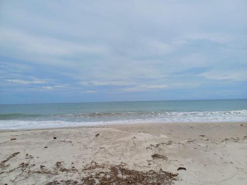 a sandy beach with the ocean in the background at Eco camping JASAL in Calabolo
