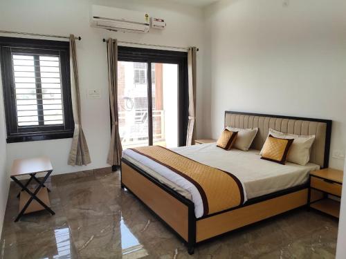 a bedroom with a large bed in a room with windows at Pushp-Raj in Jodhpur