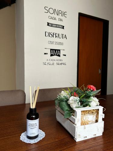 a bottle of wine sitting on a table with flowers at Duplex confortable en Caleta Olivia in Caleta Olivia
