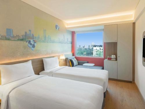 Una habitación de hotel con dos camas y una ventana. en ibis Thane - An Accor Brand, en Thane