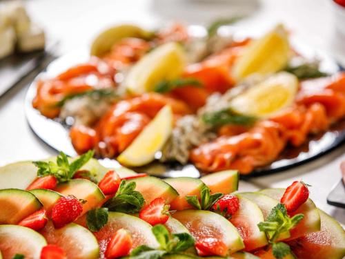 a group of plates of food with strawberries and fruit at Mercure Paignton Hotel in Paignton