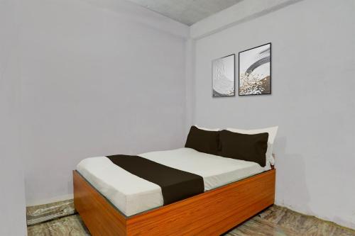 SPOT ON Anmay في Phāphāmau: غرفة نوم بها سرير في غرفة بيضاء