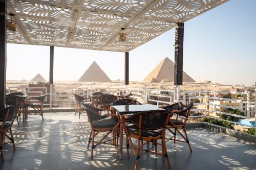 a view of the pyramids from a restaurant with tables and chairs at Pyraking Pyramids View Hotel in Giza