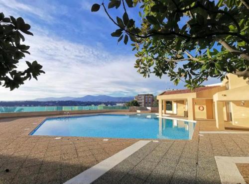 a swimming pool in front of a building at Le Cocon in Nice