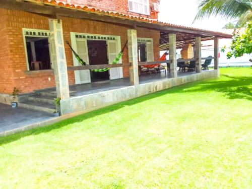a patio of a house with a grass yard at Wind Villa Cumbuco - Casa in Cumbuco