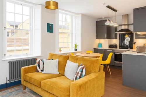 a living room with a couch and a kitchen at Dream Stays Bath - Beau Street Apartments in Bath