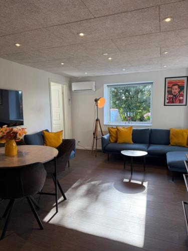 a living room with a blue couch and a table at Hygge Green Retreat Billund 101 in Grønbjerg