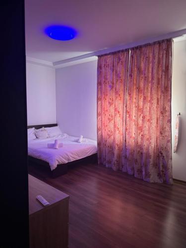 a bedroom with a bed and a curtain at Nova in Bacău