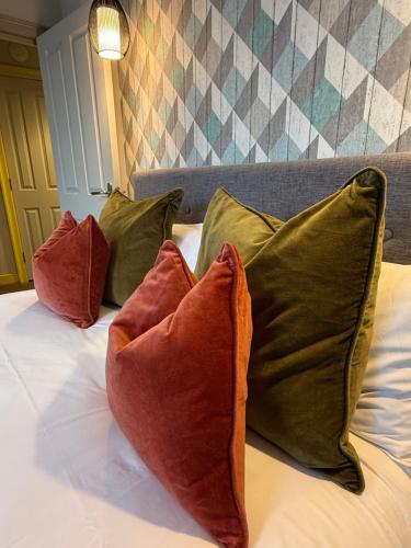 three pillows sitting on top of a bed at Dream Stays Bath - Beau Street Apartments in Bath