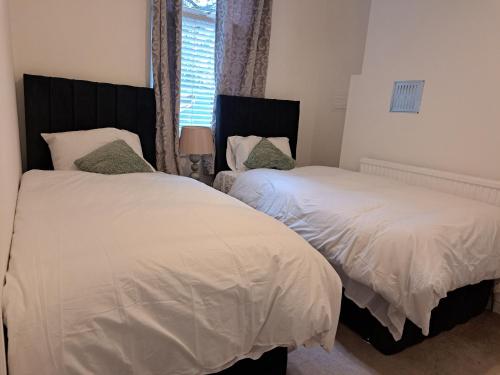 two beds sitting next to each other in a bedroom at Stretford Residence in Manchester