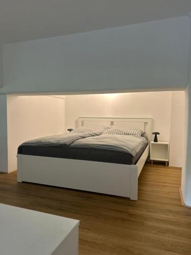 a white bedroom with a large white bed in it at Loft19 in Euskirchen
