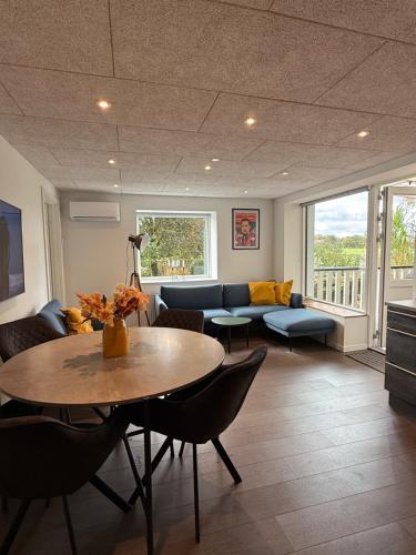 a living room with a couch and a table at Hygge Green Retreat Billund 101 in Grønbjerg