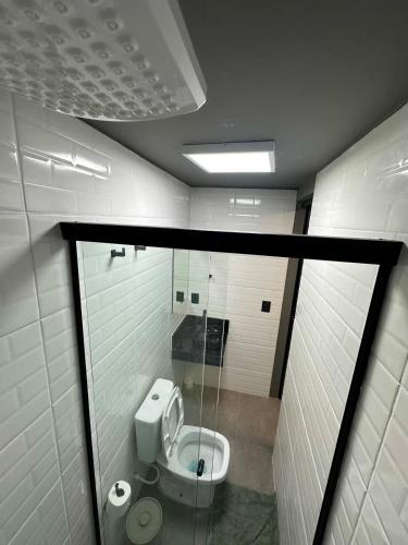 een badkamer met een toilet en een glazen raam bij Apartmento aconchegante no centro da capital in Brasilia