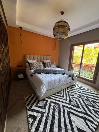 a bedroom with a large bed and a rug at Accès direct piscine - appartement avec jardin in Marrakesh