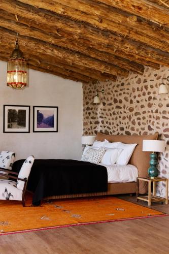 a bedroom with a large bed and a stone wall at Dar Imiri in Ourika
