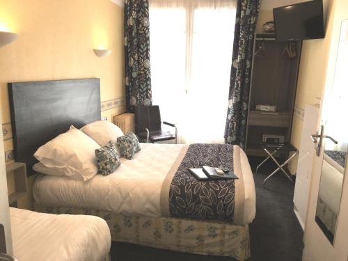 a hotel room with two beds and a television at Hotel Cayrons Vence & St Paul de Vence in Vence