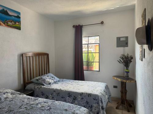 a bedroom with two beds and a window at Habitación en casa familiar in Antigua Guatemala
