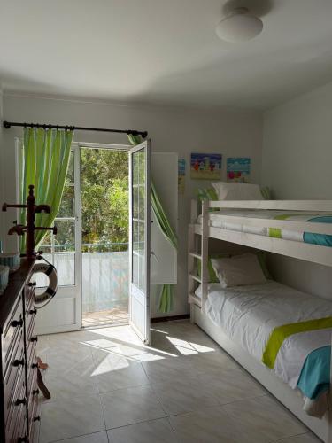 a bedroom with a bunk bed and a sliding glass door at Casa Macedo in Vila Real de Santo António