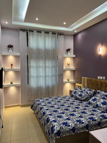 a bedroom with a bed with a blue and white blanket at EZK Appart in Kika