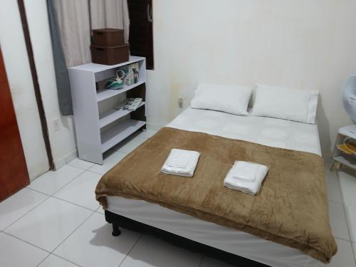 a bedroom with a bed with two towels on it at Casa temporada 3 quartos Barra nova C in Marechal Deodoro