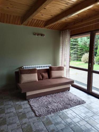 a couch sitting in a room with a large window at Sosnowa Polana in Lipinki