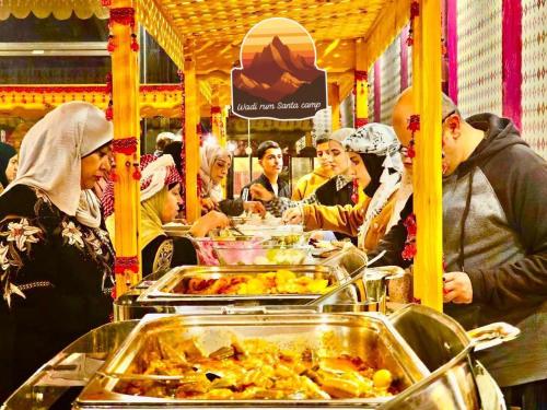 a group of people eating food on a food cart at Wadi Rum Santa Camp in Wadi Rum
