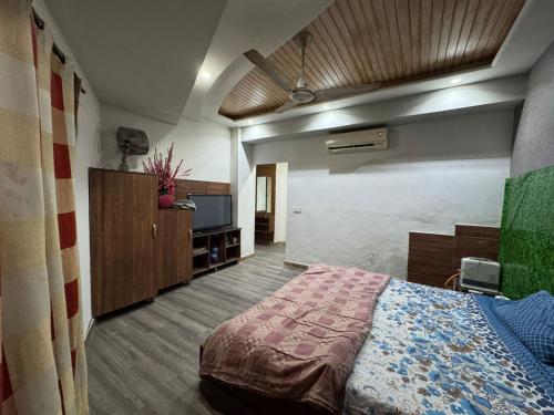 Un dormitorio con una cama y un televisor. en Platinum Apartment, en Rawalpindi
