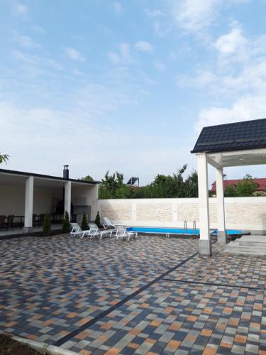 ガルニにあるWhite house Garniのパビリオンと椅子とプールのあるパティオ