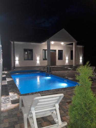 ガルニにあるWhite house Garniの夜間のスイミングプール(ベンチ付)