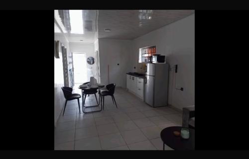 a kitchen with a table and chairs and a refrigerator at Apache appartement in Paramaribo