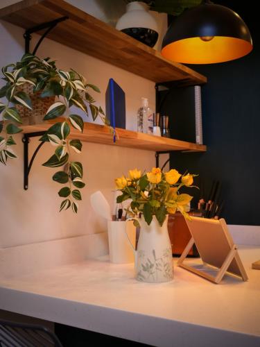 a desk with a vase of flowers and a laptop at Durham City Centre Hideaway - Terrace with View & Parking in Durham