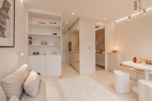 sala de estar blanca con mesa y sofá en Zilte Rust, en Knokke-Heist
