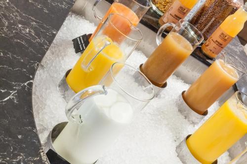 ein Tisch mit zwei Gläsern Milch und Orangensaft in der Unterkunft Van der Valk Hotel Oostzaan - Amsterdam in Oostzaan