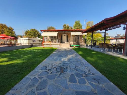 a backyard with a stone walkway and grass at Villa Sofia By The Sea in Leptokaria