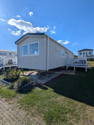 a tiny house is sitting on a yard at Modern Style Pet Friendly Holiday Home sited on Durdle Door Holiday Park in West Lulworth