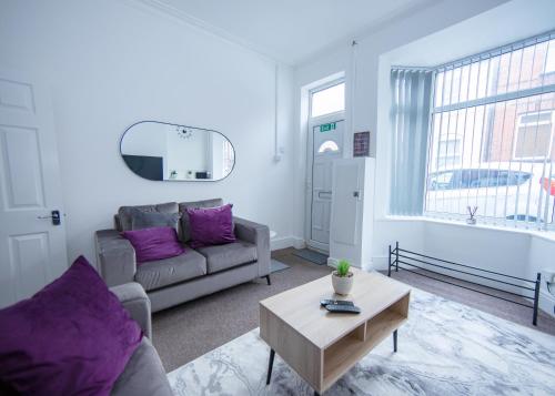 a living room with a couch and a table at Modern 3-Bed House - Stoke on Trent in Stoke on Trent