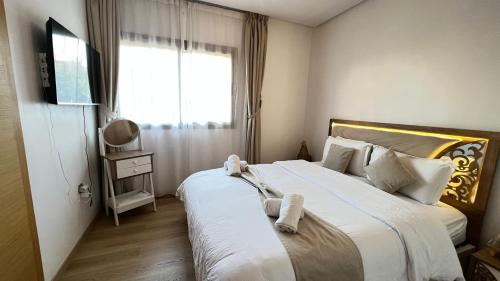 - une chambre dotée d'un grand lit avec un ours en peluche dans l'établissement mini-villa situee dans une residence Prestigia à Marrakech, avec une vue sur la piscine et le golf une securite 24h sur 24 et une proximite ideale de l aeroport 5 minutes C est une offre parfaite pour des vacances, à Marrakech