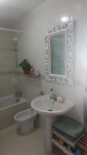 コティージョにあるLa Concha sunsetの洗面台、トイレ、鏡のあるバスルーム