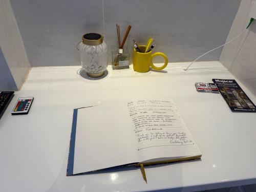 モハカルにあるSunrise Suiteの机の上には開いた本とペンとカップが置いてある