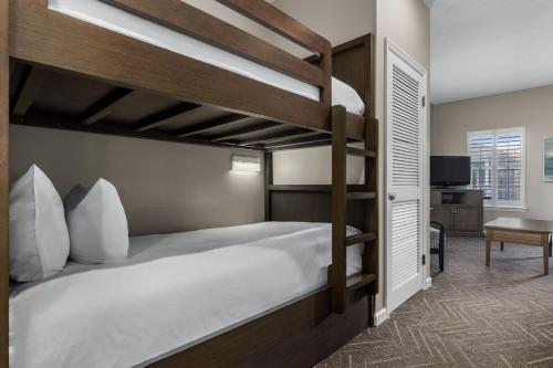a bedroom with two bunk beds and a desk at Club Wyndham Beach Street Cottages in Destin