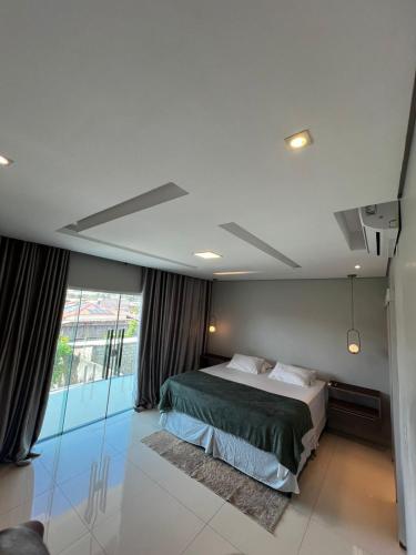 a bedroom with a bed and a large window at Mansão Duplex Santarém in Santarém
