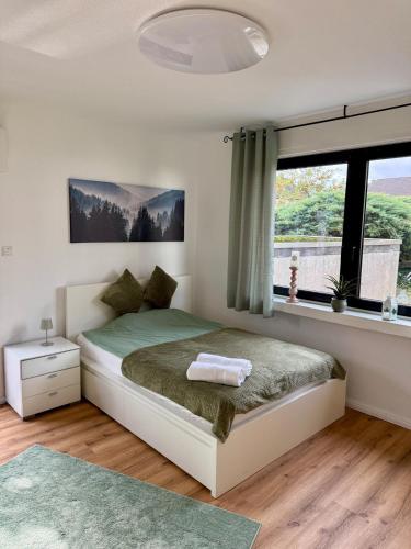 Un dormitorio con una cama y una ventana grande. en Grüne Oase in Stadtnähe, en Unna