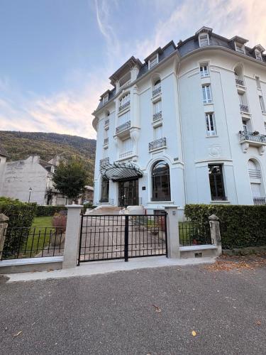 a white building with a gate in front of it at Évasion tout confort au T3 bis Pyrénées Palace in La Celle-sous-Gouzon